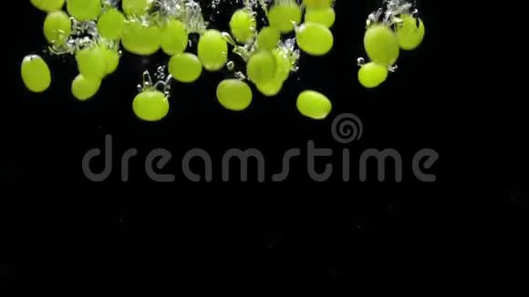 绿色葡萄在黑色背景下落入透明水视频的预览图