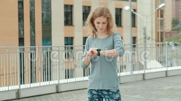 美丽的微笑健身女性在跑步前使用跑步应用程序跟踪智能手表的步伐快乐的微笑运动视频的预览图