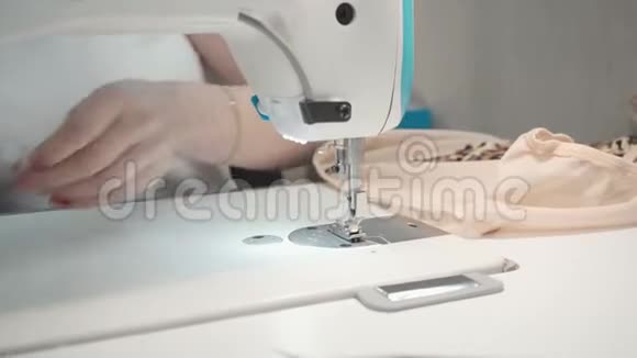 女裁缝在车间电动机器上缝制衣服的视频视频的预览图