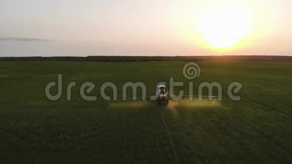 日落时用喷雾器除草剂和杀虫剂喷洒农用拖拉机的空中景观农业机械视频的预览图