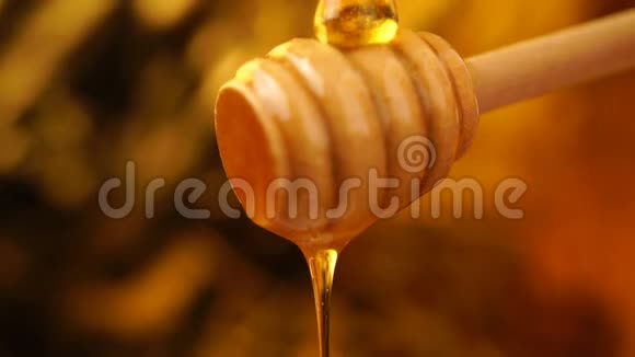 从木制蜂蜜勺子背景中滴出有机蜜视频的预览图