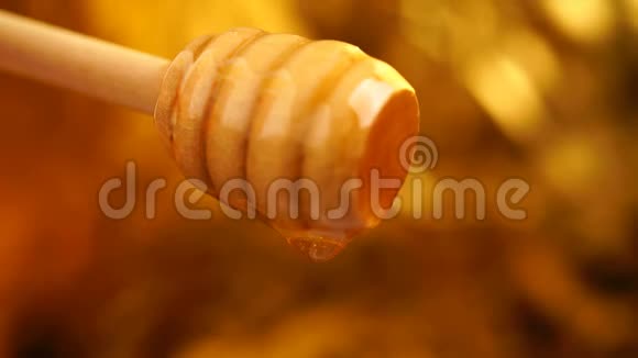 从木制蜂蜜勺子背景中滴出有机蜜视频的预览图