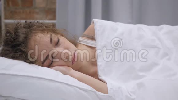 夜晚睡在床上的美丽年轻女性视频的预览图