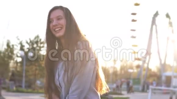 迷人的女孩穿着公园里的衬衫阳光明媚微笑视频的预览图