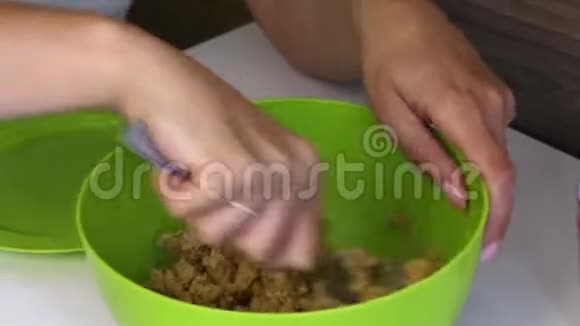 一个女人把一块饼干和炼乳混合在一起做蛋糕的基本食物视频的预览图