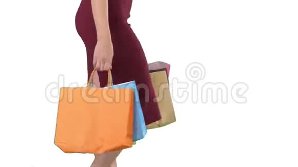 女人拿着购物袋白色的背景上走着五颜六色的路视频的预览图