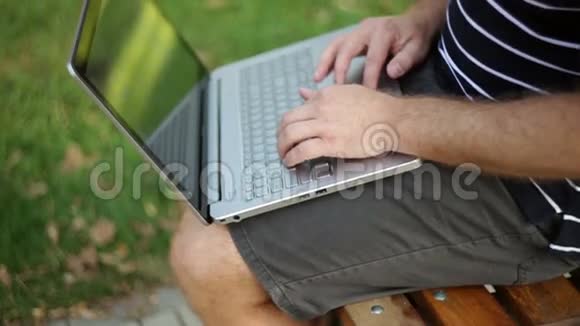 有笔记本电脑的商人坐在公园里视频的预览图