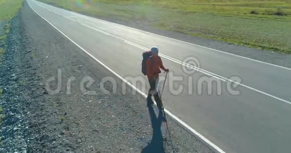 乘坐搭便车游客在沥青路上行走夏日的乡村山谷背包徒步旅行者视频的预览图