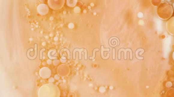 金色气泡中的五颜六色的颜料在砂液中有机地移动视频的预览图