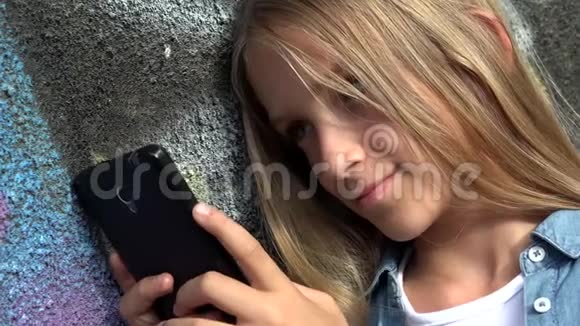 儿童使用智能手机儿童使用智能手机女孩户外公园视频的预览图