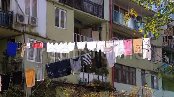 城市贫困地区一栋多层建筑上的一根绳子上挂着和烘干的衣服视频的预览图