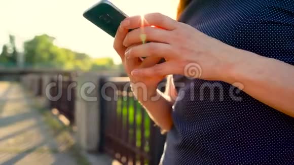 日落特写镜头时在户外使用智能手机的女人视频的预览图