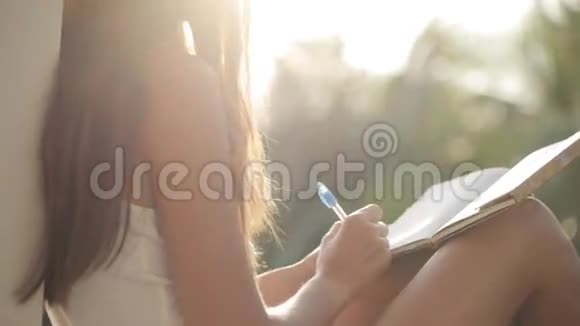 女人坐在阳台上写日记背景是花园视频的预览图
