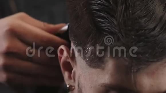 帅哥为理发店的黑发男子做一个近距离理发现代发型师近距离视频的预览图