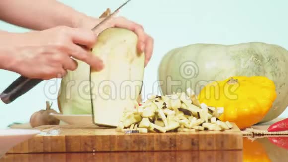 女手用刀切茄子蔬菜混合物用于烹饪蔬菜炖背景色4k视频的预览图