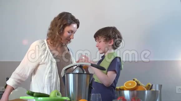 白种人年轻母亲和儿童自制鲜橙果汁并饮用视频的预览图