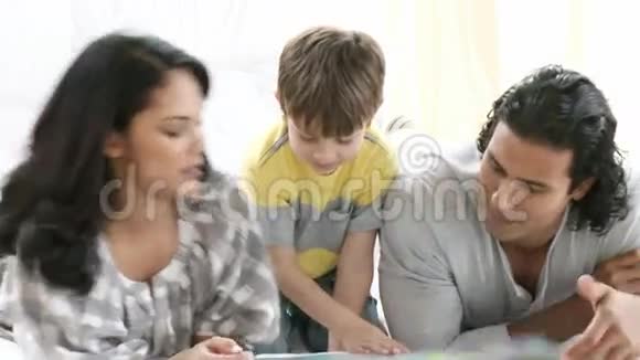 年轻的家庭阅读在地板上视频的预览图