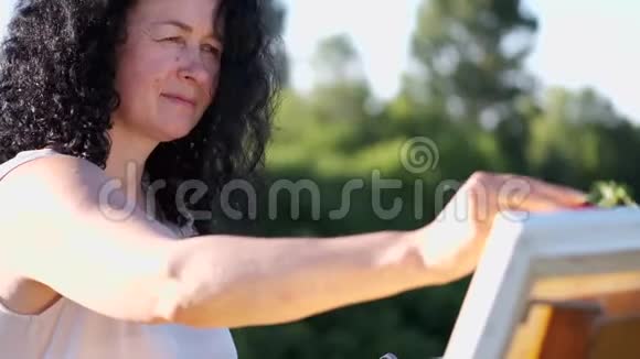 女画家在户外画彩色画视频的预览图