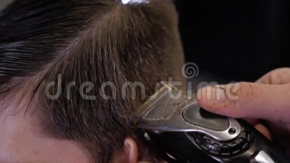 帅哥为理发店的黑发男子做一个近距离理发现代发型师近距离视频的预览图