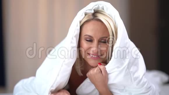 早上在家里的床上笑着快乐的女人视频的预览图