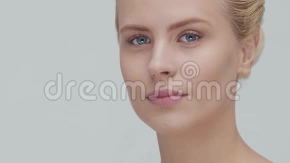 工作室肖像年轻美丽和自然金发妇女应用护肤霜面部提升化妆品和制作视频的预览图