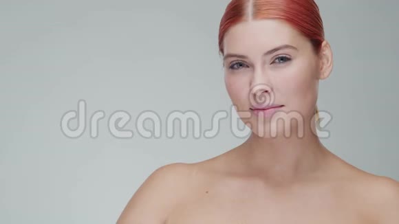 工作室肖像年轻美丽和自然红发妇女应用护肤霜面部提升化妆品和制作视频的预览图