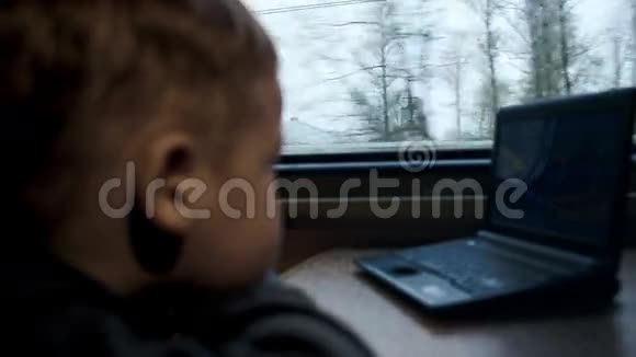 男孩在笔记本电脑上看电影或卡通视频的预览图