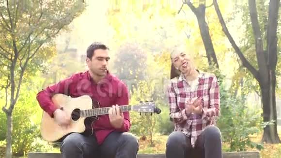 在公园弹吉他和唱歌的男女青年视频的预览图
