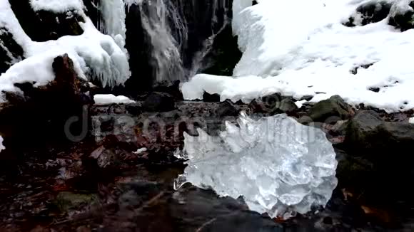 美丽的大冰有抽象的裂缝冰柱瀑布石溪河岸视频的预览图