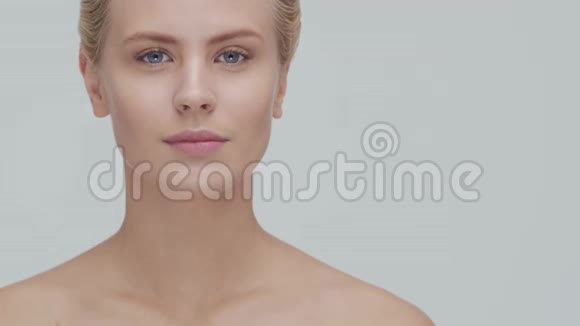 工作室肖像年轻美丽和自然金发妇女应用护肤霜面部提升化妆品和制作视频的预览图