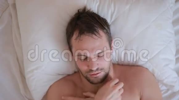 一个发烧的男人躺在家里的床上视频的预览图