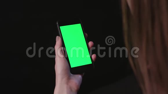 女人拿着手机绿色屏幕轻敲视频的预览图