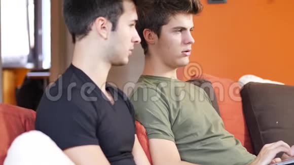 两个年轻的男性朋友用笔记本电脑视频的预览图