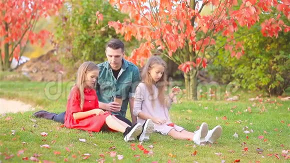 在公园美丽的秋日爸爸和孩子们的家人视频的预览图