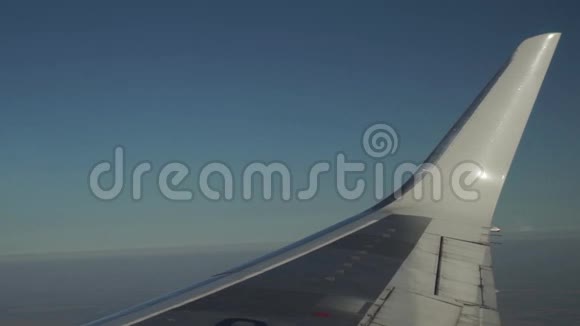 飞机正通过白云在蓝天上飞行从窗户看到飞机机翼视频的预览图