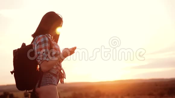 hipsterhiker剪影女孩漫游者在手机智能手机上搜索位置导航视频的预览图