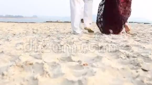 一个男人和一个女人沿着海滩散步视频的预览图