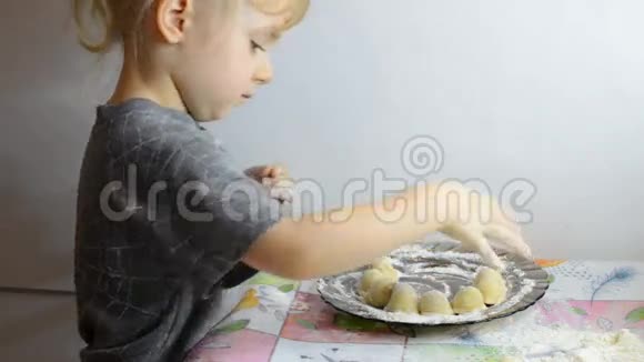 有趣的小女孩用肉平面团和烹饪饺子视频的预览图