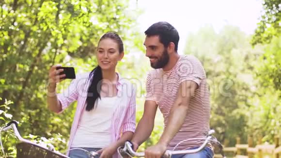 一对骑自行车的情侣用智能手机自拍视频的预览图