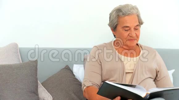 成熟的女人看着她的相册视频的预览图