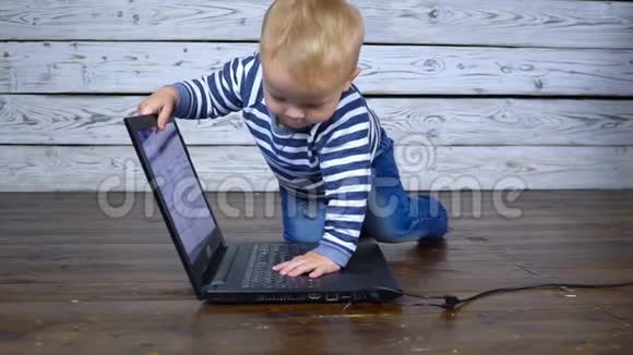 漂亮的一岁孩子用笔记本电脑玩商务视频的预览图
