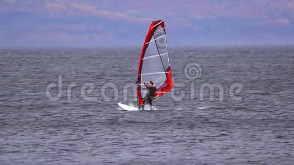 一个男运动员对风帆运动很感兴趣在秋天的一天他在一个大湖上的帆板上移动视频的预览图