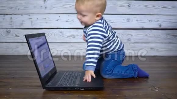 漂亮的一岁孩子用笔记本电脑玩商务视频的预览图