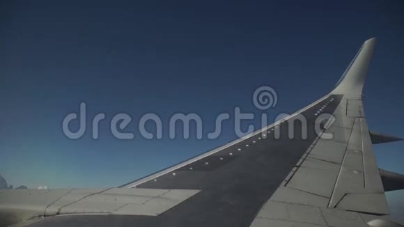 飞机正通过白云在蓝天上飞行从窗户看到飞机机翼视频的预览图