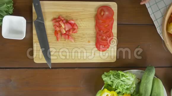 女主厨在厨房里做沙拉健康食品和切番茄视频的预览图
