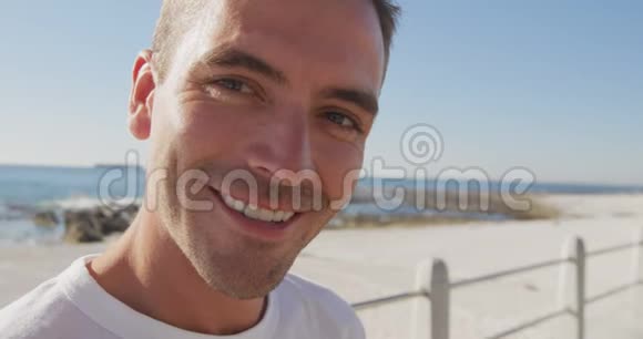 一个年轻人在海滩上微笑的肖像视频的预览图