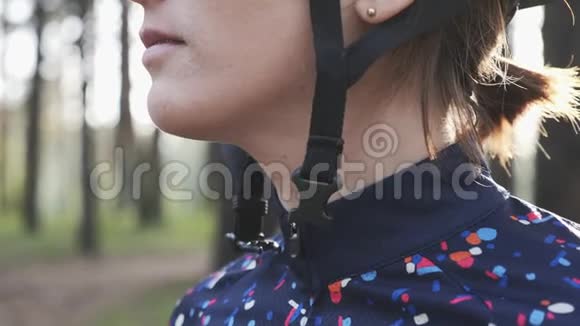 年轻的骑自行车的女孩在骑自行车前把头盔上的线束拉紧自行车的概念慢动作视频的预览图