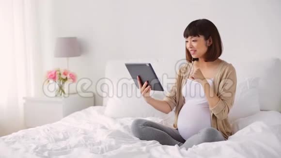 快乐的亚洲孕妇带平板电脑回家视频的预览图