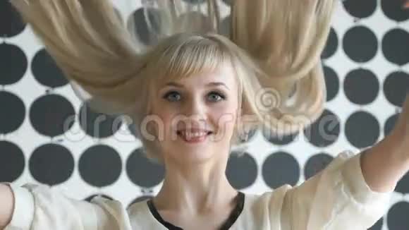 在美容院留着浓密头发的金发女郎视频的预览图