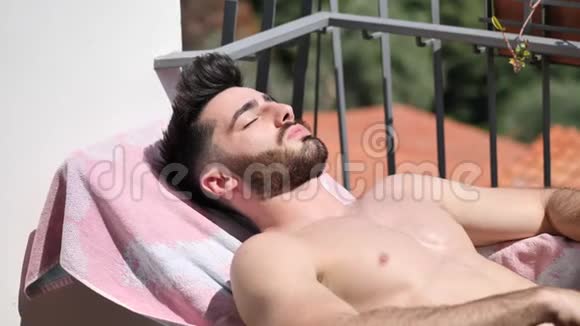 青年男子日光浴休息室椅子视频的预览图